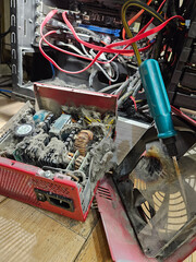 Computer case with a green screwdriver in it. The screwdriver is being used to remove a burnt out...