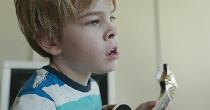Caucasian Kid Play Mandolin at Home. European Boy Practice Music 4K 10-bit