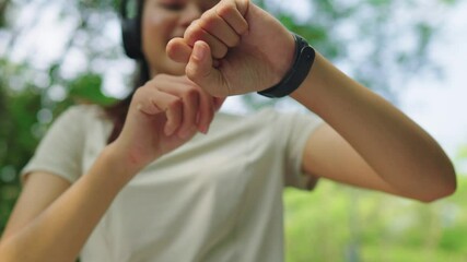 Asian woman jogging in the morning with smart watch chatting with friends and checking heart rate. Watch with digital technology modern health exercise pure nature - Powered by Adobe