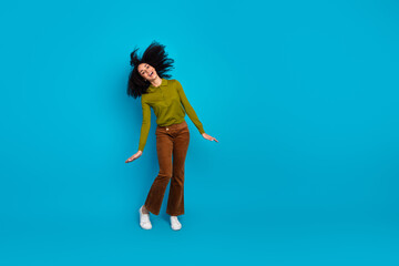 Obraz premium Young charming woman joyfully posing against a vivid blue backdrop wearing trendy casual attire with a cheerful attitude