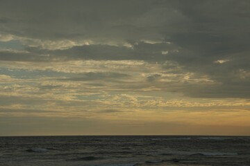 Beautiful wavy sea under cloudy sky at sunset