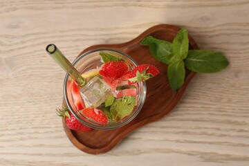 Tasty refreshing drink with strawberries, lemon and mint on wooden table, top view