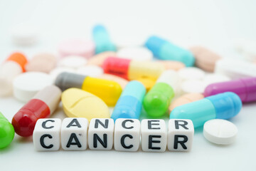 Cancer word with pills and capsules medical drug.