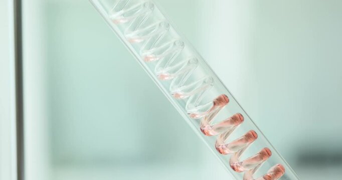 Graham condenser features spiraled inner tube filled with red substance used in cooling. Equipment considers condensation of vapors in laboratory