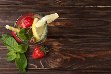 Refreshing drink with strawberries, lemon and mint on wooden table, flat lay. Space for text
