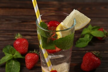 Refreshing drink with strawberries, lemon and mint on wooden table, closeup