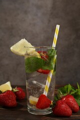 Refreshing drink with strawberries, lemon and mint on wooden table against grey textured background, closeup