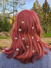 Woman girl with red hair has a flowery headband. The flowers are white and are scattered throughout...