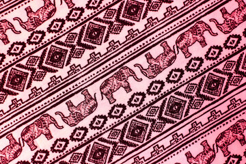 pink fabric with elephants on it. geometric background with animals
