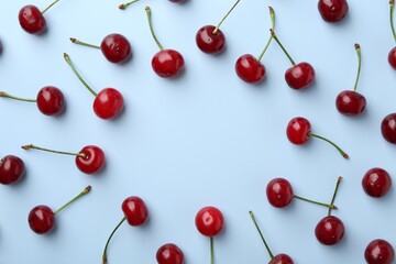 Frame of fresh ripe cherries on light background, flat lay. Space for text