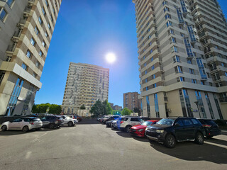 Parking lot with a row of cars and a building in the background housing estate condominium. The...