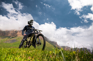 Male athlete cyclist in helmet and protective mask outdoors. MTB rider in mountainous terrain...