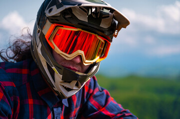 Young man standing on mountain bike or moto bike outdoors. Portrait of confident sportsman...