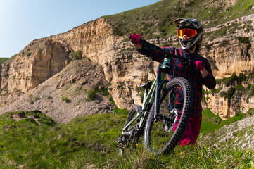 Cyclist man on mountain bike outdoors. Male tourist riding bicycle on grassy trail in mountains...