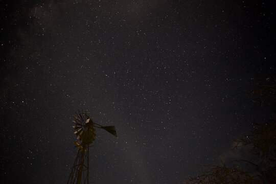 Night sky with stars and a windmill in the foreground