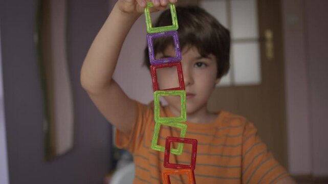 Magnetic Force Demonstration Showing Attraction. Boy Playing With Magnetic Tiles Stacking Blocks Game Set Toy. Development of Attention and Imagination. Creativity and Learning in Childhood.