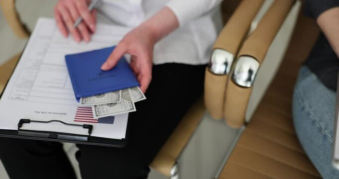 Business people fill visa application forms surrounded by American flags and money during meeting at consulate office. Travel and immigration matters
