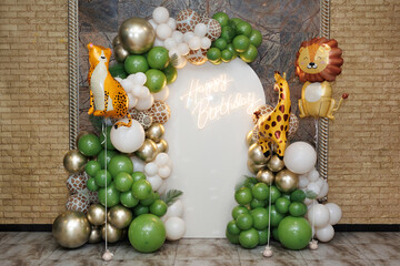 Photo zone from balloons in the style of safari and zoo. Balloons with a giraffe, leopard and lion.