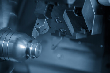 The CNC lathe machine groove cutting the metal mold parts in the light blue scene.