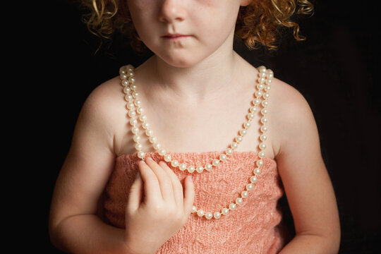 Close up of a little girl wearing a pearl necklace