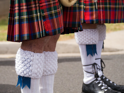 Two male Scottish Band players wearing kilts