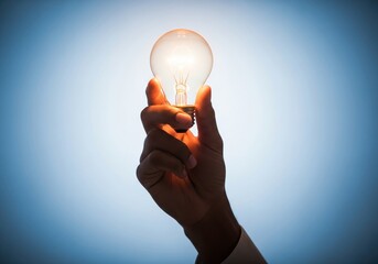 A hand holds a glowing light bulb, symbolizing ideas, innovation, and bright solutions.