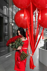 Young woman in a red dress with large helium balls and flowers.