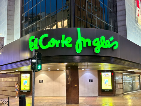 Alicante, Spain - June 24, 2025: El Corte Ingles store exterior at night with vibrant green signage, showcasing urban shopping experience and modern architecture in city center