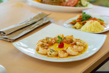 Table served with shrimp in garlic sauce and assorted side dishes