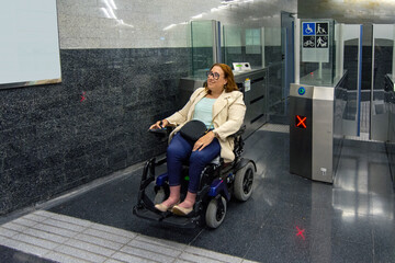 Woman in wheelchair entering subway station through accessible entrance. Concept of inclusion