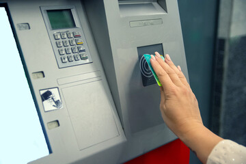 Woman using contactless payment at atm machine. Concept of inclusion, adapted public transport