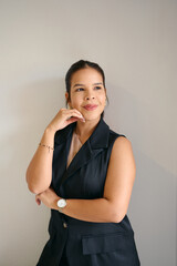 Confident woman poses in stylish outfit against neutral background