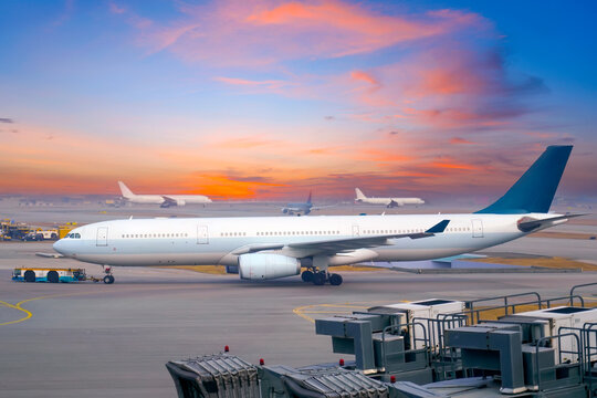 Passenger planes prepare for take off early in the morning at a major airport. Flights depart at dawn.