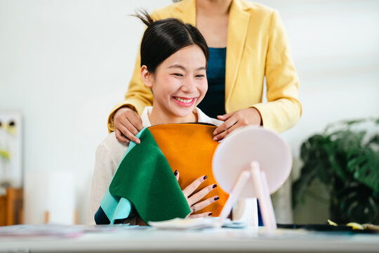 Image consultant showing color swatches and explaining personal tone selection to female client in studio