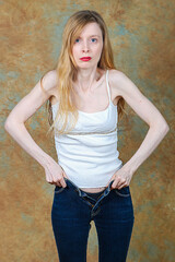 Woman putting skinny jeans on herself and closing the zipper