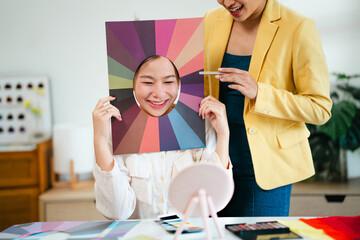 Color specialists consulting female customer with personal palette guide and fabric samples at...