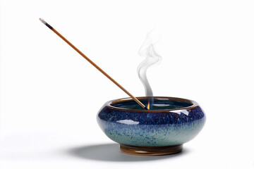 Incense stick burning in decorative bowl with smoke rising