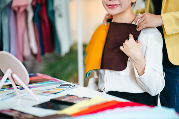Stylist explaining personal color palette to client during consulting session inside fashion image...