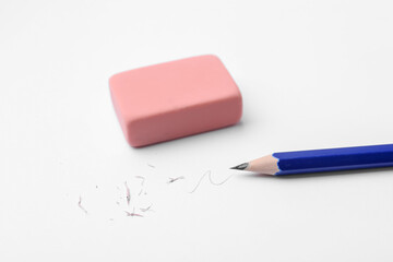 Pencil, eraser, doodle and scraps on white background, closeup