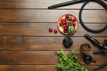 Flat lay composition with traditional hookah parts on wooden table, space for text