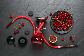 Hookah and cherries on black table, flat lay