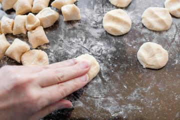 dough cut into small pieces on a cutting surface for the production of dumplings and vareniki