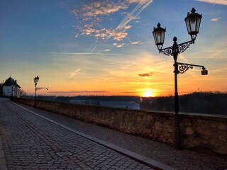 Cobblestone street with vintage street lamps at sunset