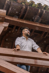 A Latino man looking at the horizon from a wooden bridge during the rain in a colonial town in...