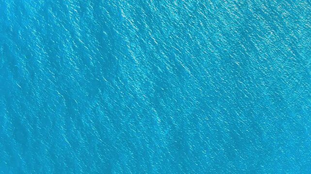 Caribbean sea texture stock video. Sea waves cover landscape. Turquoise sea water and waves 4k background. Blue lagoon surface. Vast ocean background with moderate waves, looking straight down.