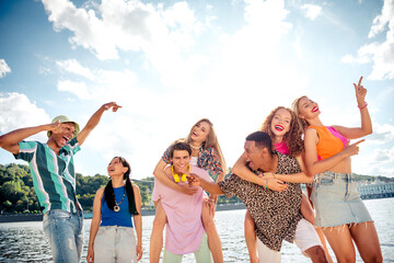 Joyful group of friends enjoying outdoor time by the water on a sunny day