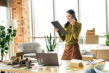 Busy entrepreneur managing her creative business from a stylish workspace filled with modern tools...