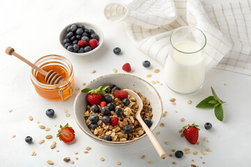 Top-down photo of a healthy breakfast with muesli, honey jar, and glass of milk. All food objects are placed ONLY in the bottom right corner of the image. The ENTIRE center and left side must be PURE 