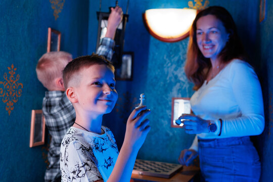 Two boys and mom in a quest room with chess complete the task.