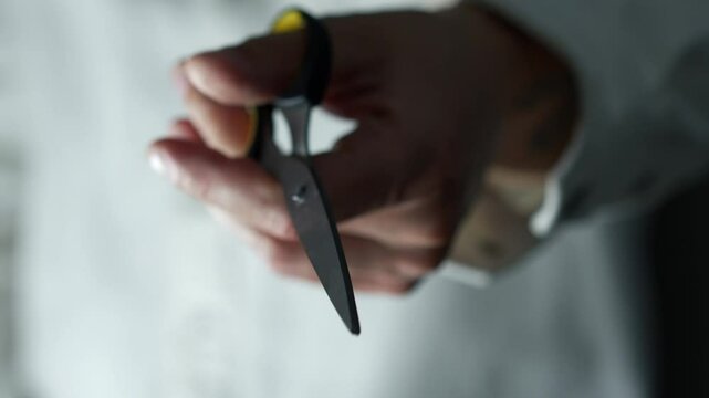A man's hand clicks scissors to show their sharpness.
A man checks his scissors.
A barber holds steel and sharp scissors before starting work.